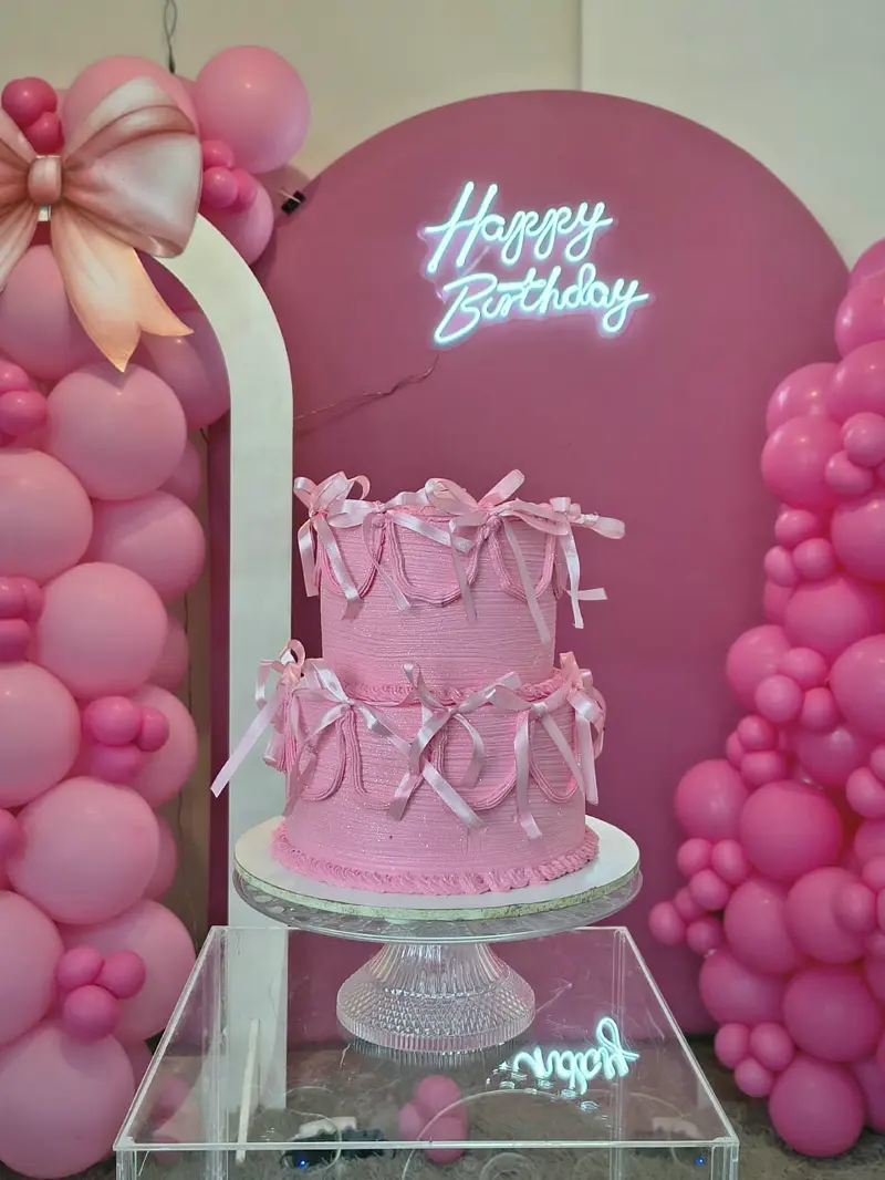 Bolo rosa de dois andares com laços