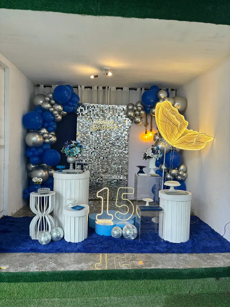 Aniversário de 15 anos em azul e prata, com painel brilhante e borboleta iluminada