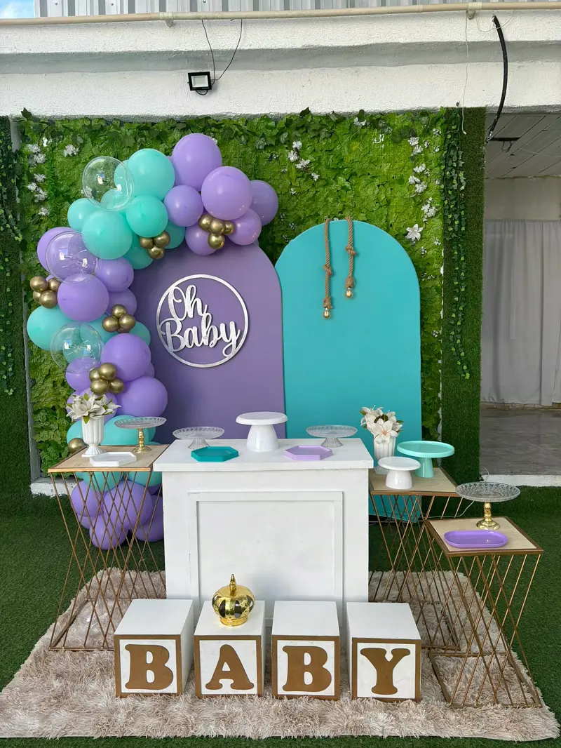 Chá de bebê em lilás e verde-água em frente ao jardim vertical