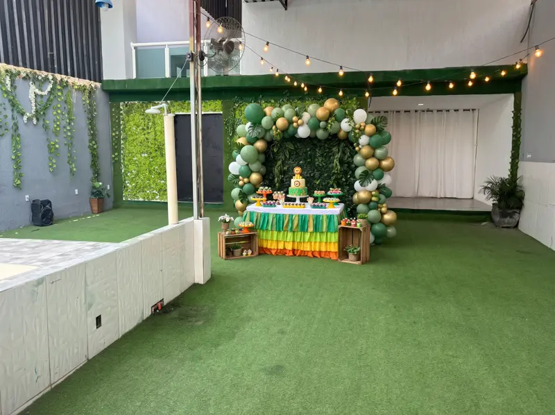 Mesa de bolo com arco de balões no jardim vertical